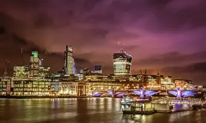 Night skyline of London as seen from the Thames riverbank