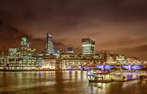 Night skyline of London as seen from the Thames riverbank