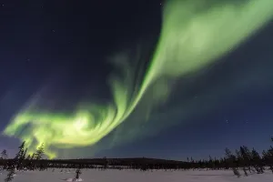 Northern Lights (Aurora borealis) over a moonlit winter landscape