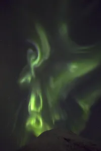Northern Lights (Aurora borealis) behind mountain top