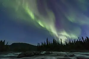 Northern Lights or Aurora Borealis above river Gamajahka or Kamajakka