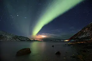 Northern Lights over fjord with winter landscape