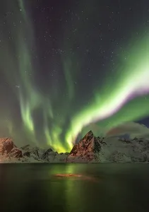 Northern lights over snow-capped mountains