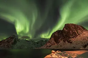 Northern lights over snow-capped mountains