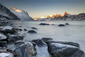 Norwegian fjord, snow-covered mountains at sunset