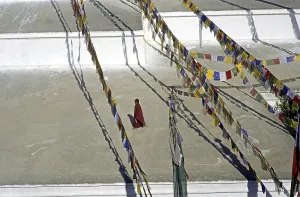 Novice walking around shrine in Bodnath