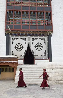 Two novices walk across the monastery courtyard