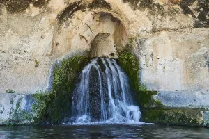 Nymph grotto, Small waterfall flowing from a rocky cave with moss growth