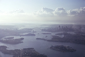 Oblique aerial view of the harbour, the bridge and the city centre skyline, Sydney, Australia 1974