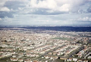 Oblique aerial view of a suburban housing estate with CBD in the distance, Melbourne, Victoria, Australia 1956