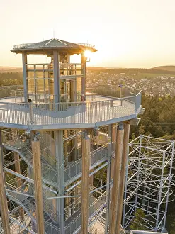 Observation tower with a view of a city in the background at sunset