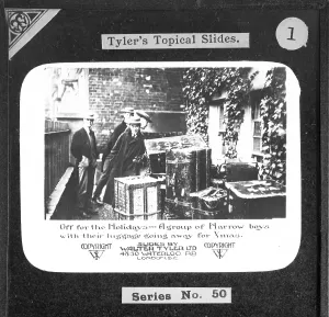 Off on holiday. A group of Harrow boys with their luggage on their way to the Christmas holidays. Walter Tyler Ltd. magic lantern slide circa 1910