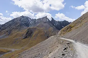 Off-road car on mountain pass, gravel road in the mountains in the Tien Shan