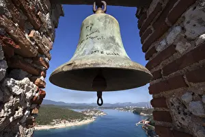 Old bell at the Morro Castle, Bahia de Santiago de Cuba bay and Cayo Granma behind