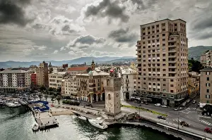 An old clock tower stand by the harbour in front of the town called Savona