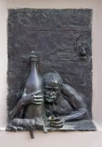 Old drunkard alcoholic and a cat bronze bas-relief
