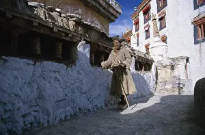 Category Buddhism Prints: Old man turning prayer wheels in Lamayuru Gompa
