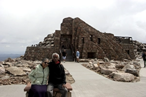 Old man and woman sitting in front of Crest House built in 1939