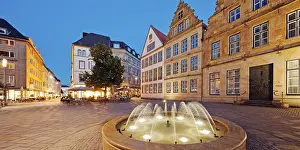 Old market with fountain and town houses in the evening