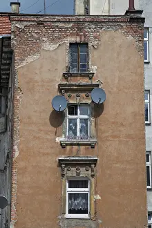 Framed Print : Old tenement house in poor condition with satellite dishes on the wall in Legnica