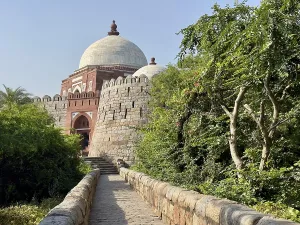An old tomb surrounded by grass under a clear sky