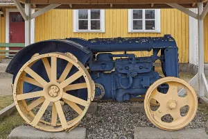 An old tractor restored and painted blue and yellow and put on display