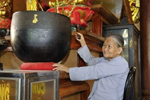Old woman hitting a sound bowl