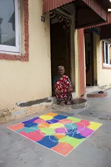 Old woman sitting in front of rangoli at Worli Koliwada