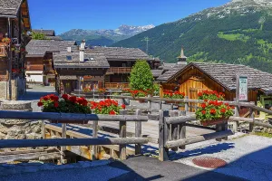 Old wooden houses with wooden shingle roofs and flower boxes in the historic centre of Grimentz