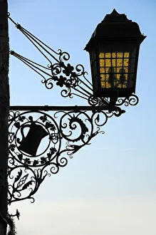 Old, wrought-iron inn sign as a silhouette on the castle building