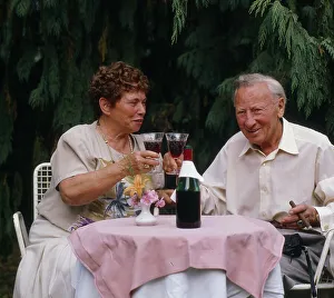 Older couple drinking red wine, terrace