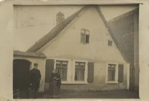 Older couple in front of their family home