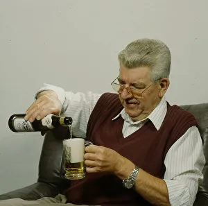 Older man pours beer into glass