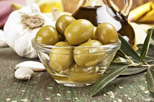 Olives with garlic and a bottle of olive oil