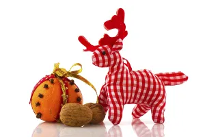 Orange with cloves walnuts and reindeer isolated over white