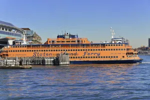 An orange-coloured Staten Island Ferry ship in the harbour
