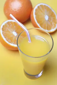 Orange juice in glass and oranges