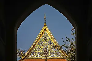 Ornate golden triangular roof of a Buddhist temple in Bangkok