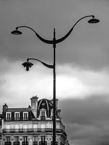An ornate street lamp rises high against a backdrop of a moody