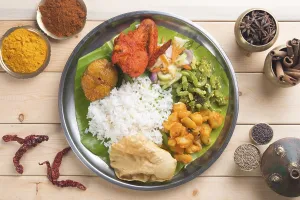 Overhead view of Indian mixed rice on wooden dining table with setting