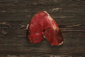 Overhead view of raw deer boneless ham over wooden background