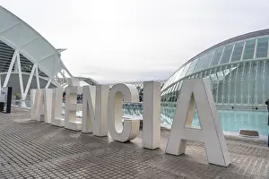 Oversized white valencia lettering on a modern promenade with the city of arts