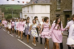 Paare gehen Hand in Hand in einer Prozession zum Abendtanz, Flora Day, Helston, Cornwall, England, UK 1973