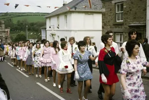 Paare gehen Hand in Hand in einer Prozession zum Abendtanz, Flora Day, Helston, Cornwall, England, UK 1973
