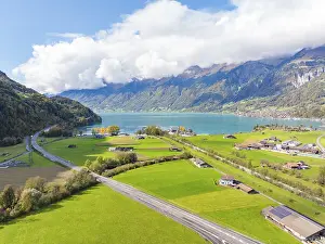 Painted meadow landscape by the lake with mountains in the background