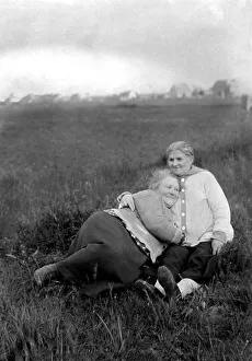 Pair, two girlfriends cuddling on the meadow