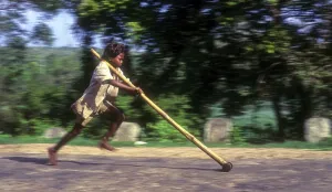 Panning, tribal boy playing improvised pulley in balle
