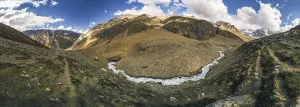 Panorama of mountains in Kashmir with stream coming down the valley