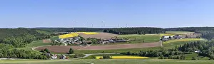 Panorama of a rural landscape with fields and wind turbines under a blue sky