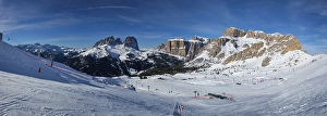 Panorama of a ski resort piste with people skiing in Dolomites in Italy